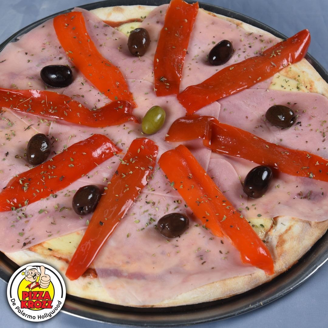 Pizza de jamón y pimiento rojo con aceitunas negras y una aceituna verde central