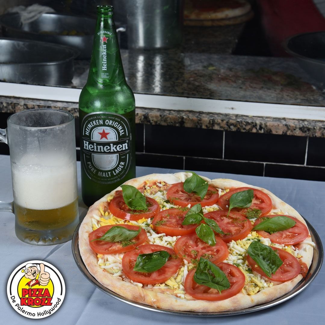 Una pizza Margherita cubierta con rodajas de tomate y albahaca