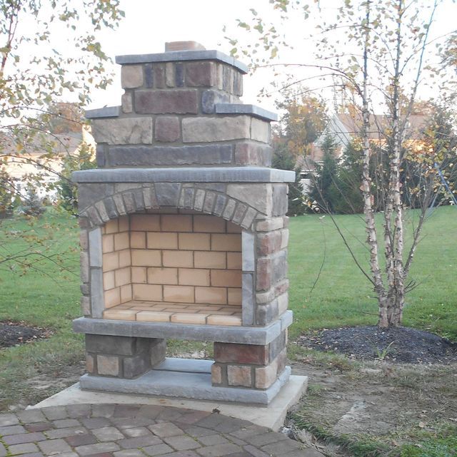 A Brick Fireplace Is Sitting in The Middle of A Lush Green Field