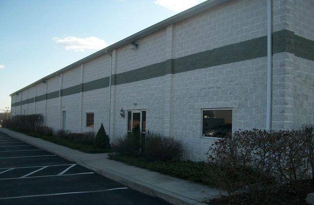 A Large White Building with A Green Stripe on The Side