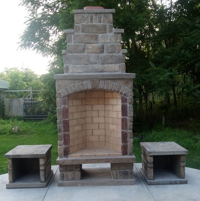 A brick fireplace with a chimney and two stools