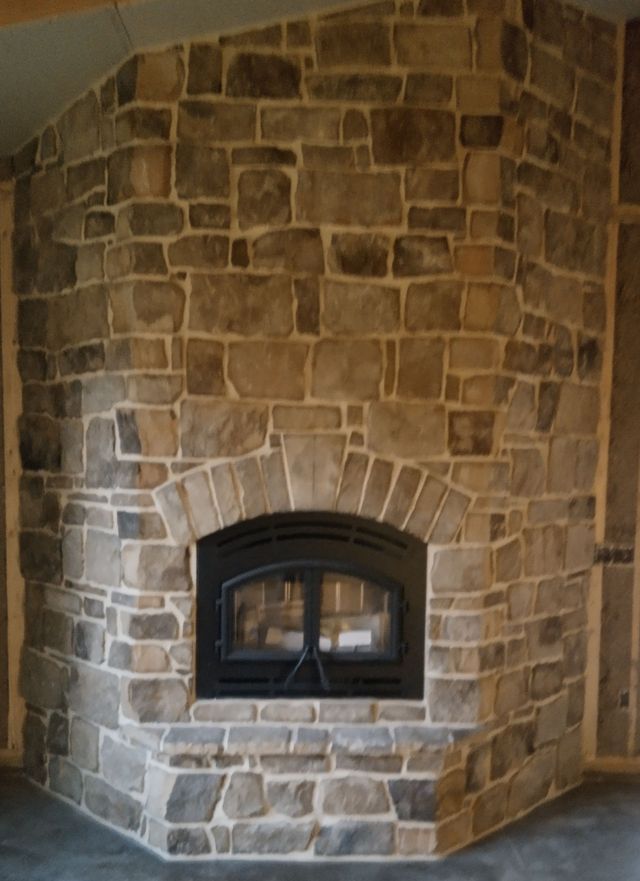 A Large Stone Fireplace with A Black Door