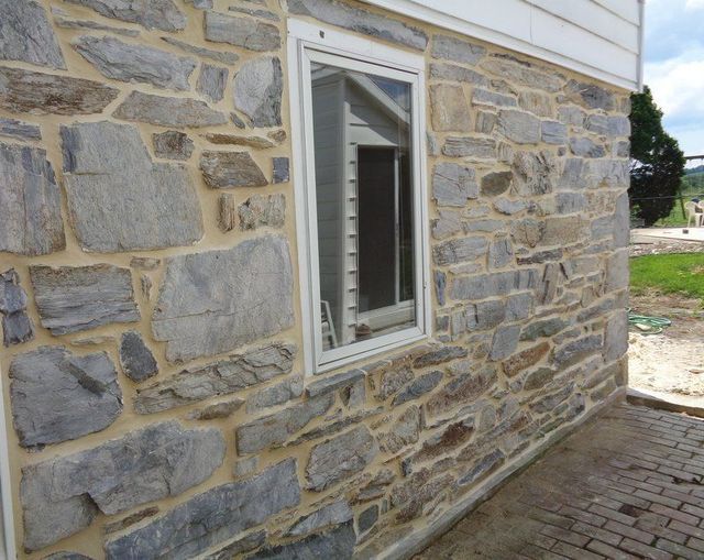 A Stone Wall with A Window on The Side of It