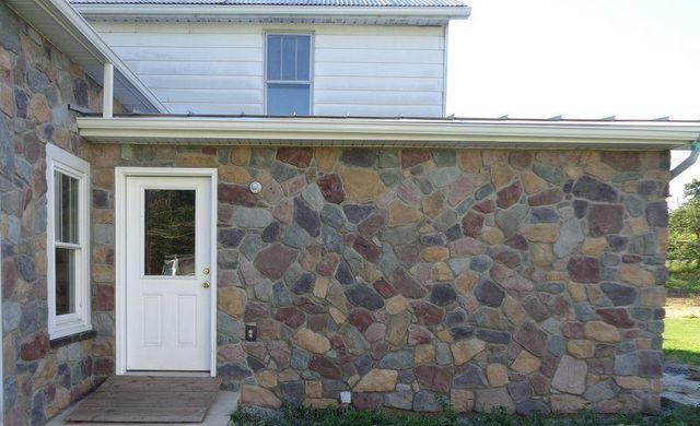 A House with A Stone Wall and A White Door.