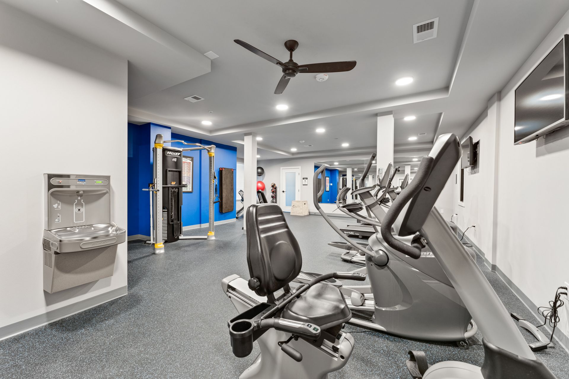 a gym with a ceiling fan and a water fountain