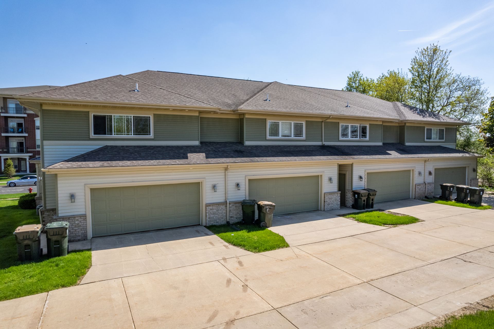 a row of houses with green garage doors