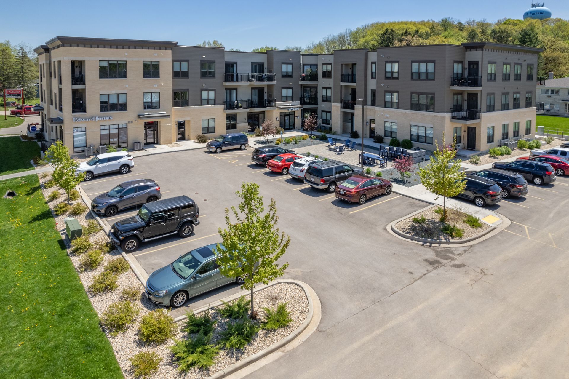 an aerial view of a parking lot with a building in the background