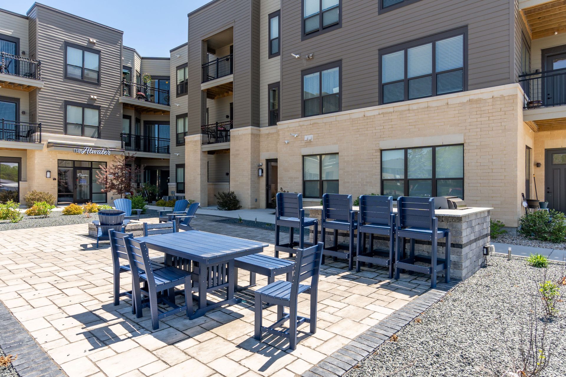 a patio with a table and chairs in front of a building that says amanda