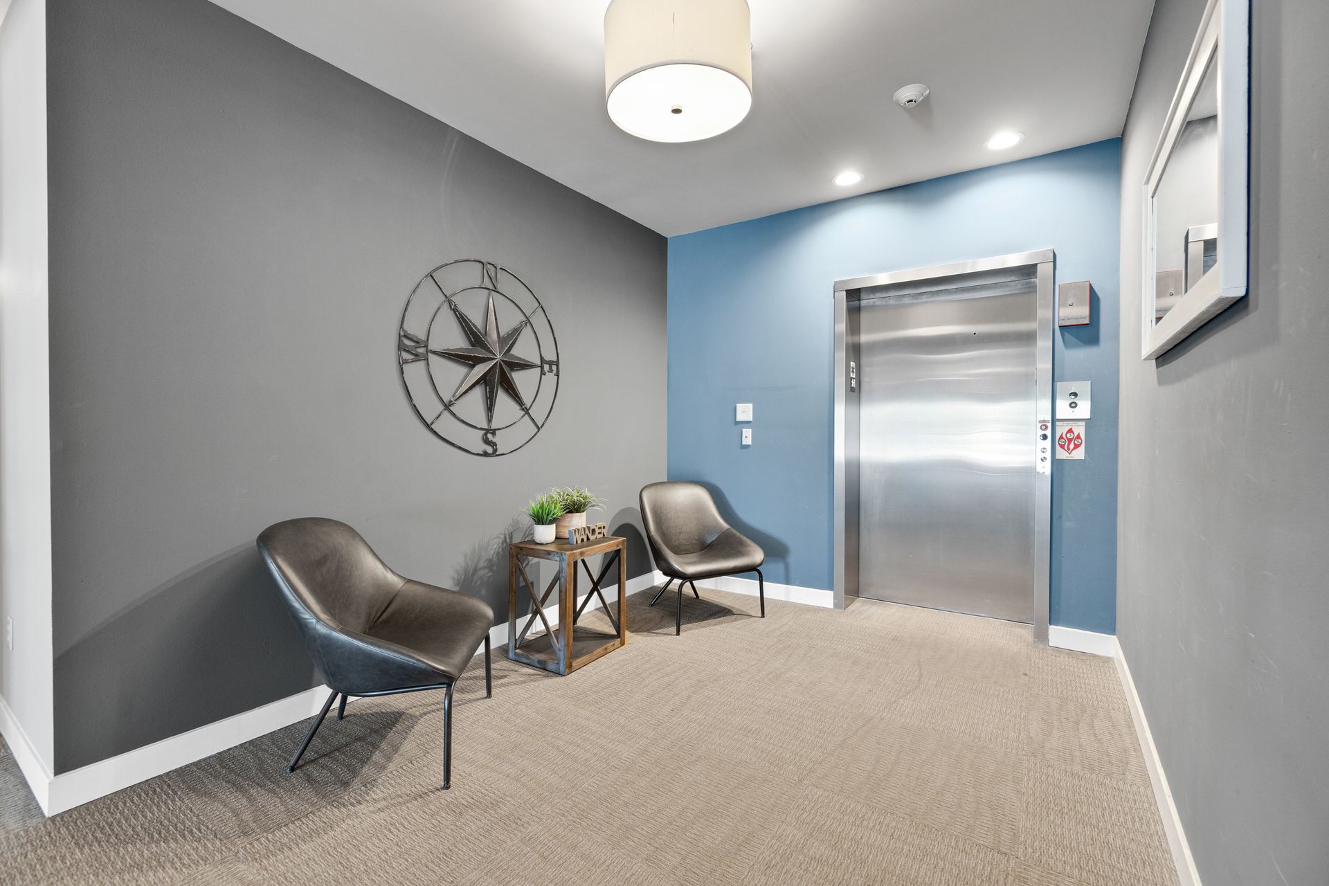 a hallway with two chairs and a compass on the wall
