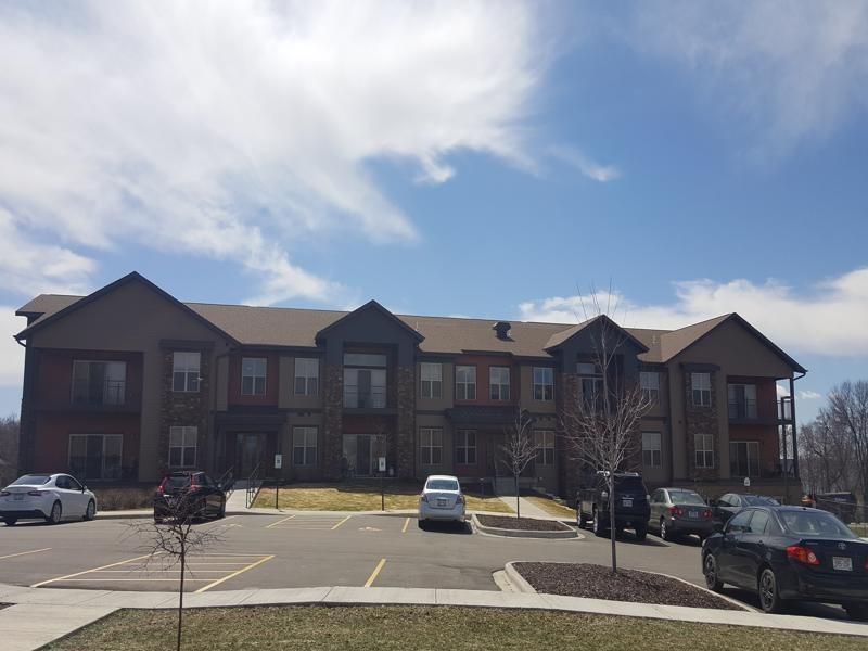 a large apartment building with cars parked in front of it