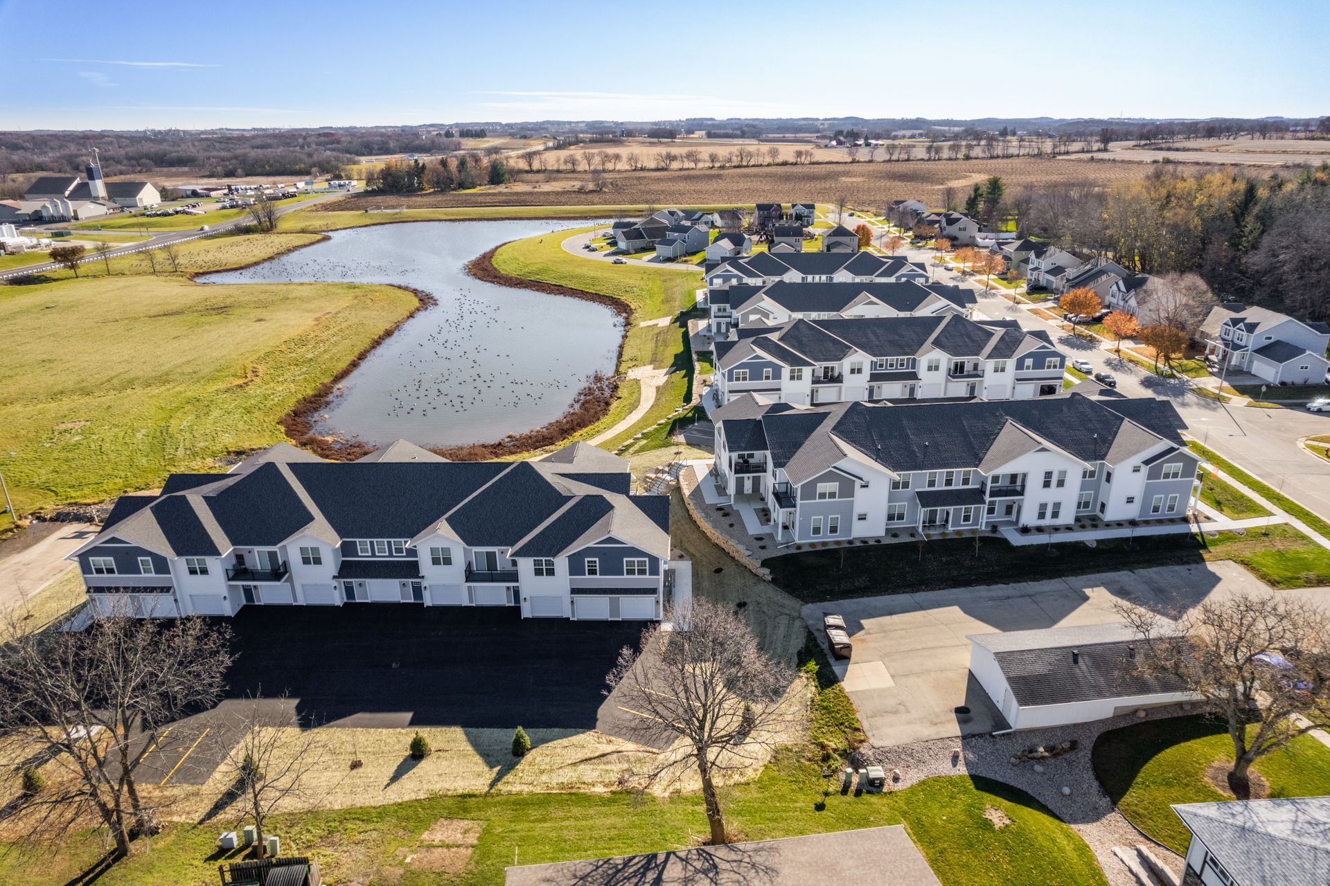an aerial view of a residential area with a lake in the middle