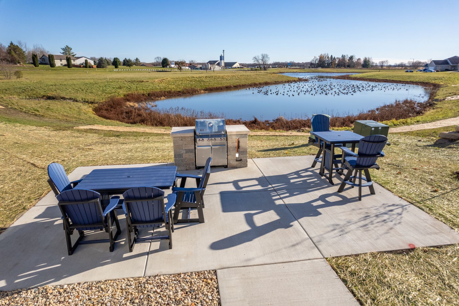 a patio with a table and chairs and a grill