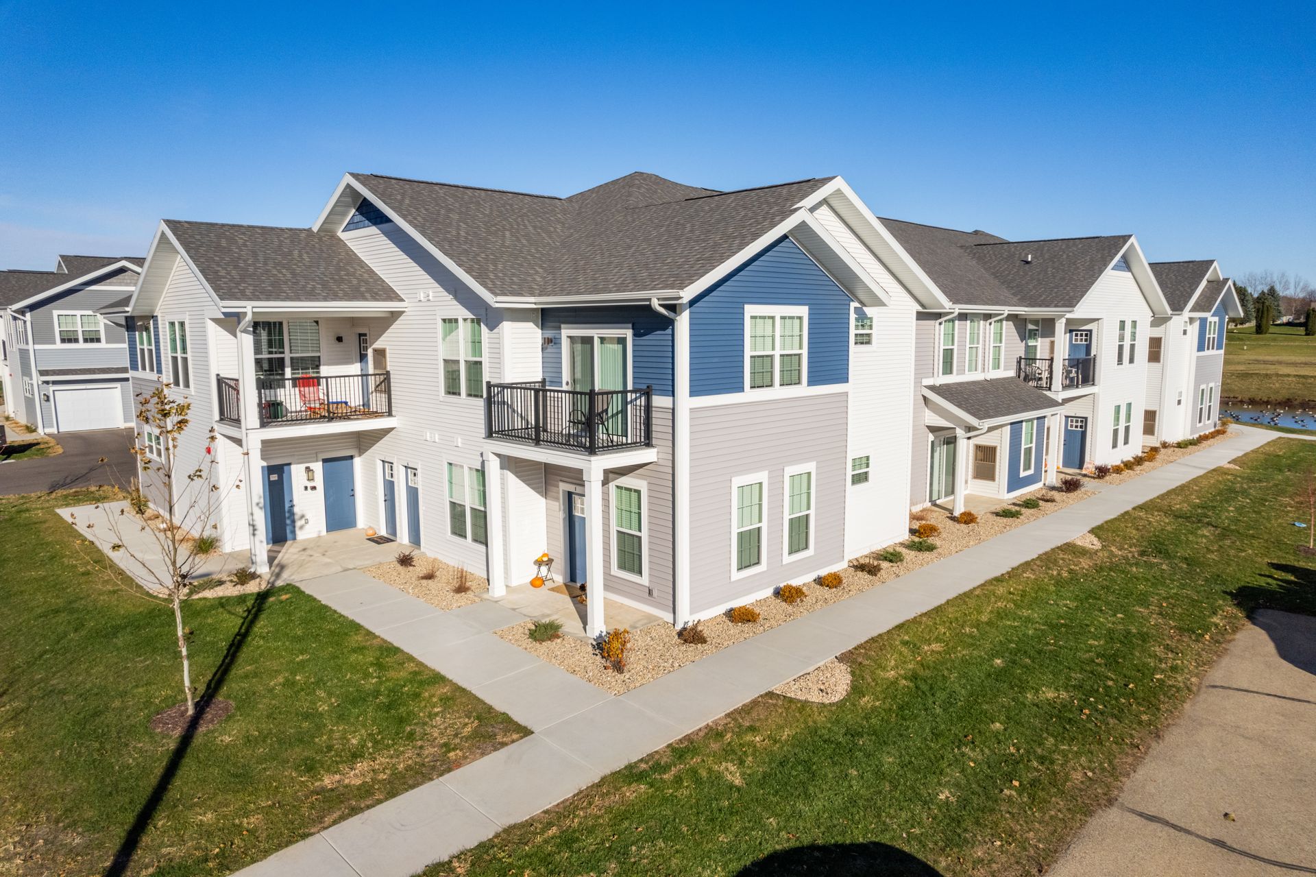 a row of apartment buildings with blue and white siding
