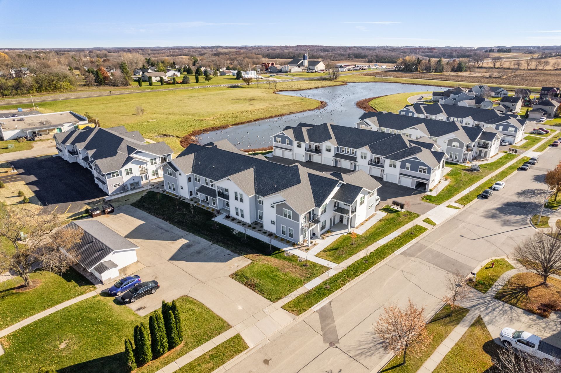 an aerial view of a residential area with a lake in the middle