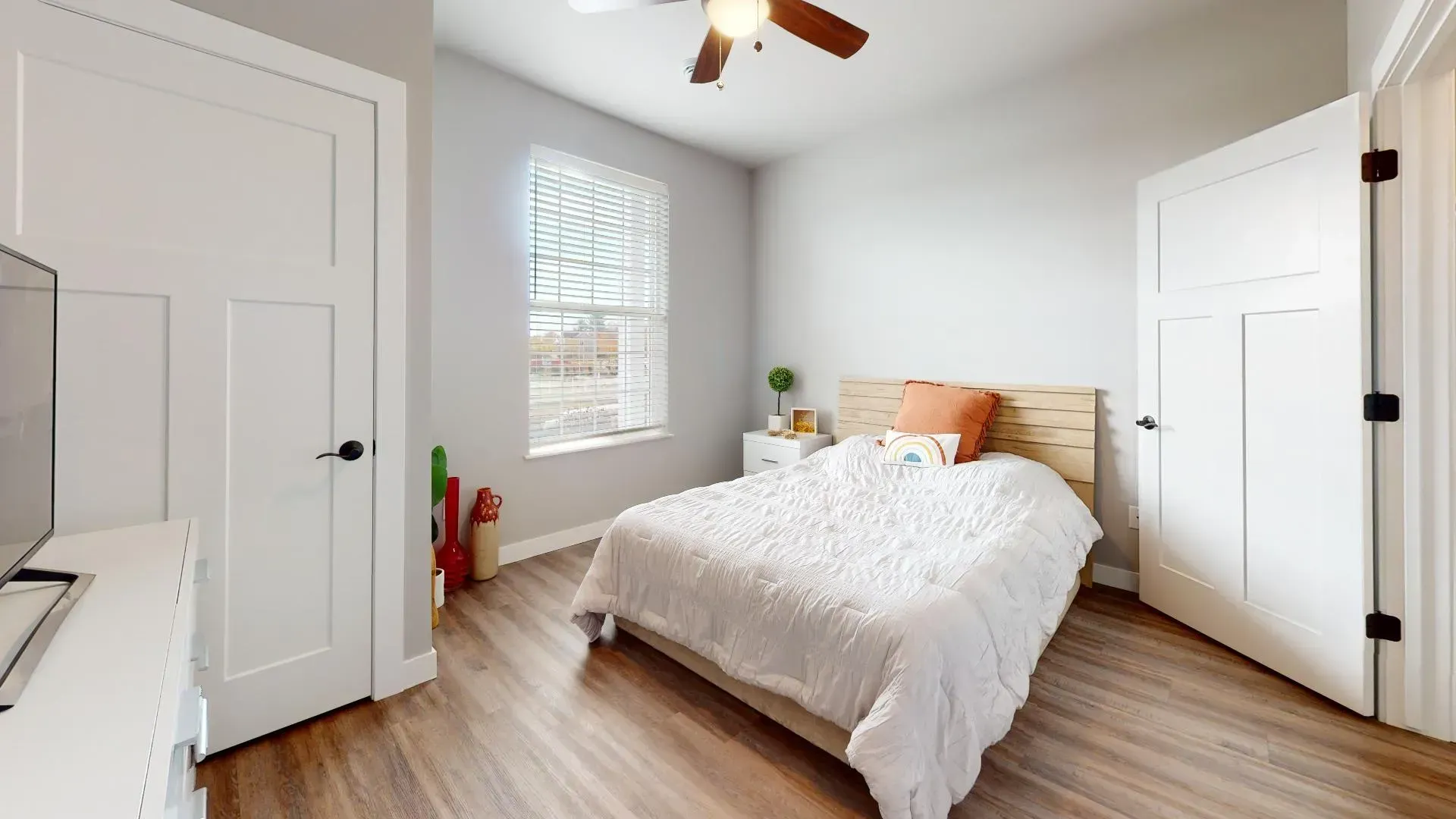 a bedroom with a bed and a ceiling fan