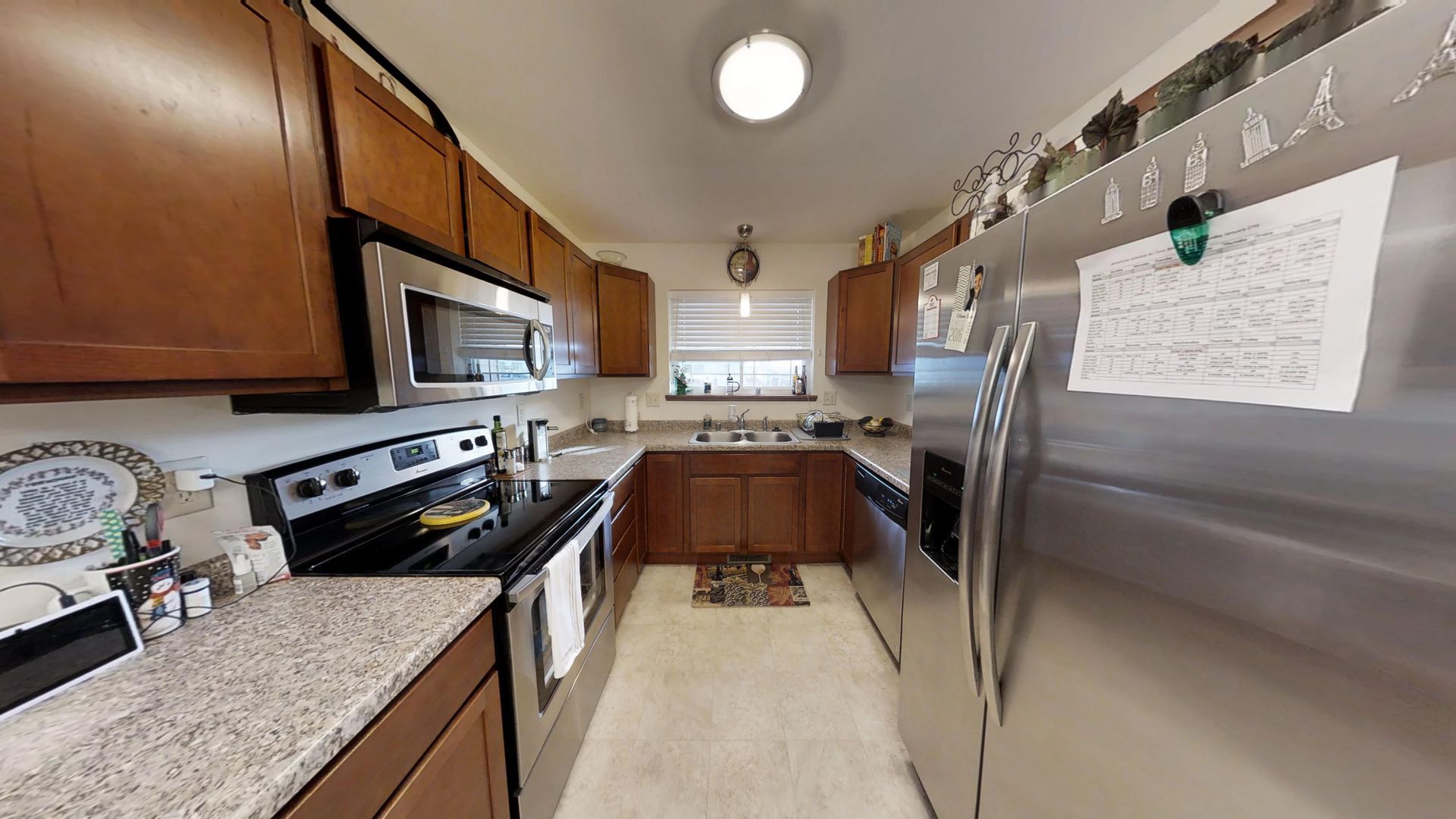 a kitchen with stainless steel appliances and a calendar on the refrigerator door