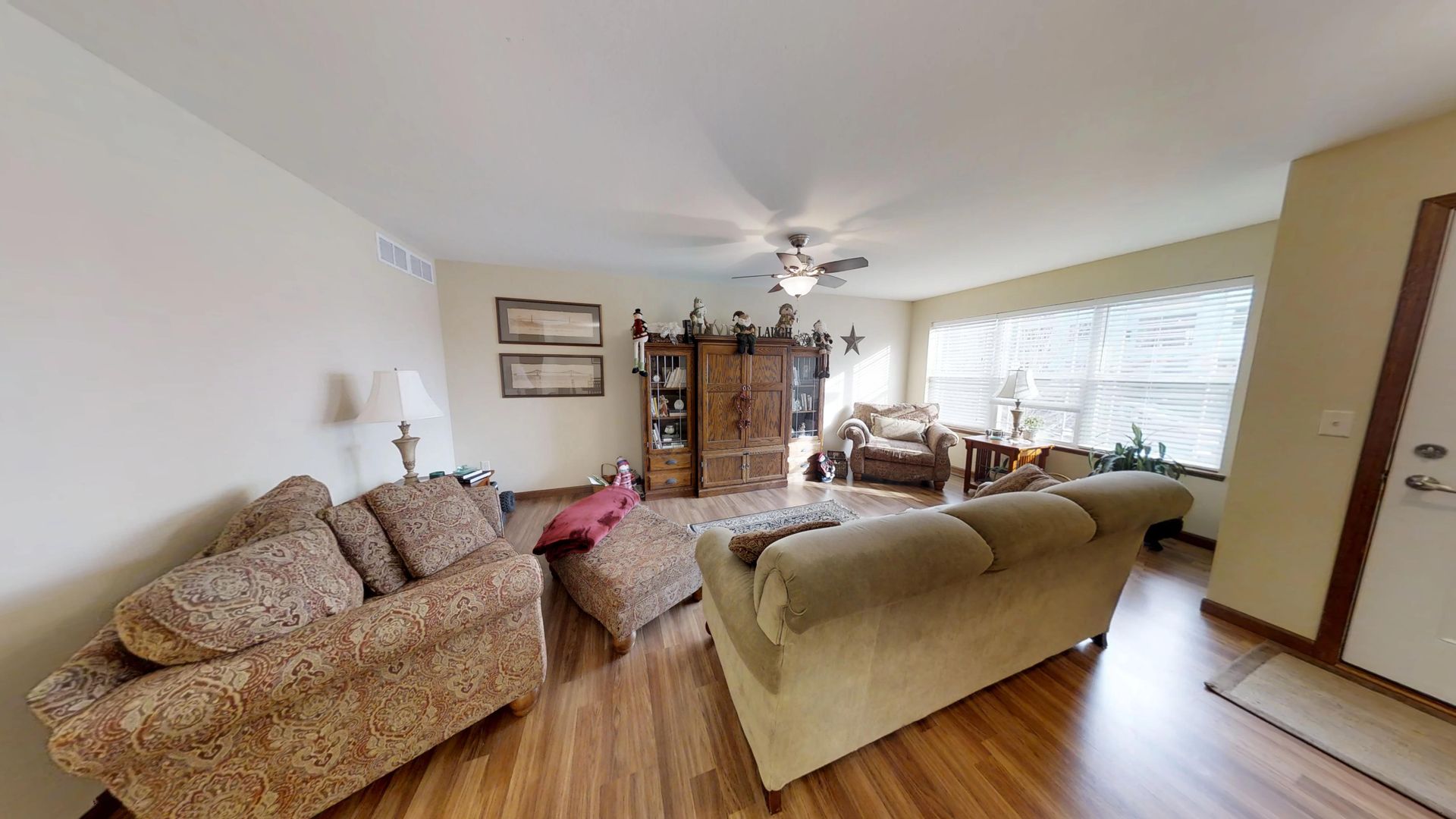 a living room with furniture and a ceiling fan