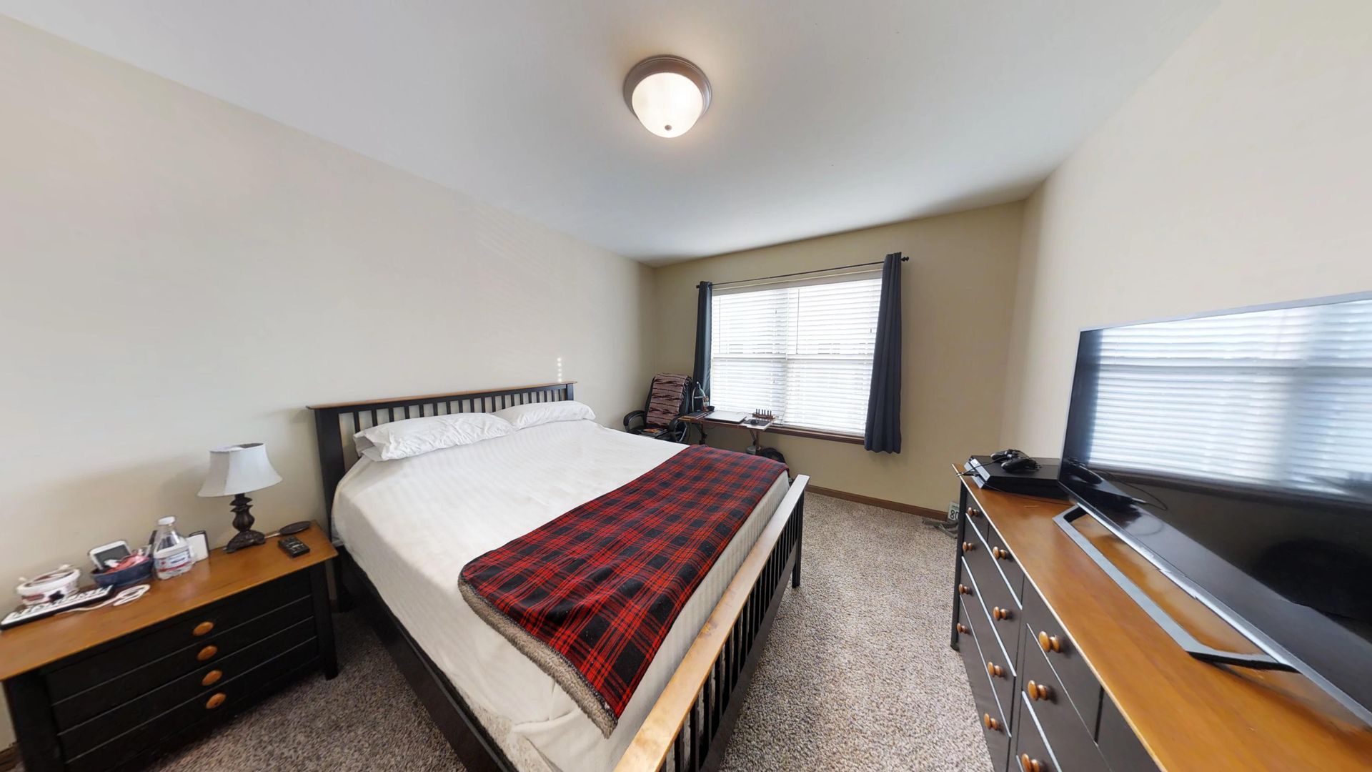 a bedroom with a king size bed and a flat screen tv