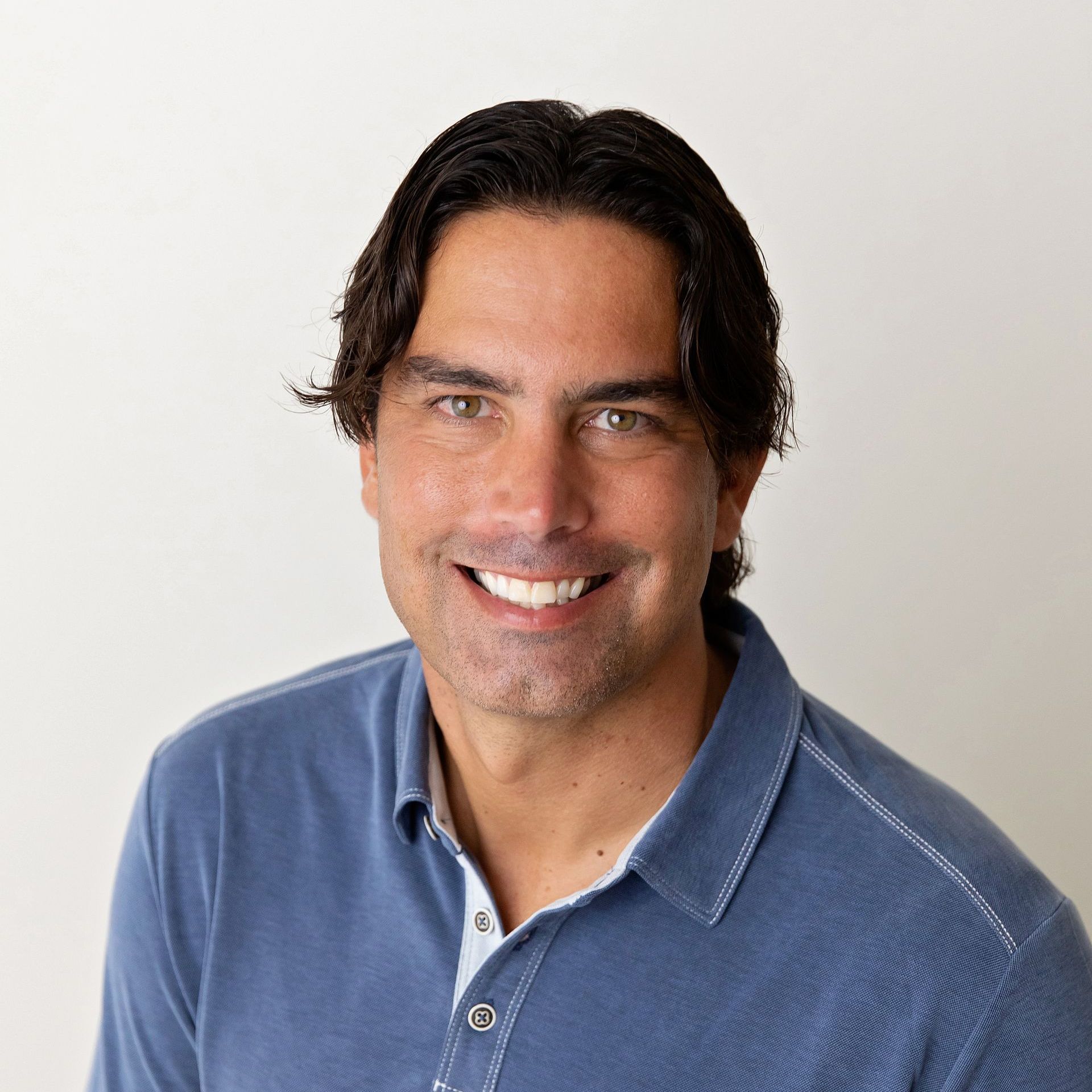 a man in a blue shirt is smiling for the camera