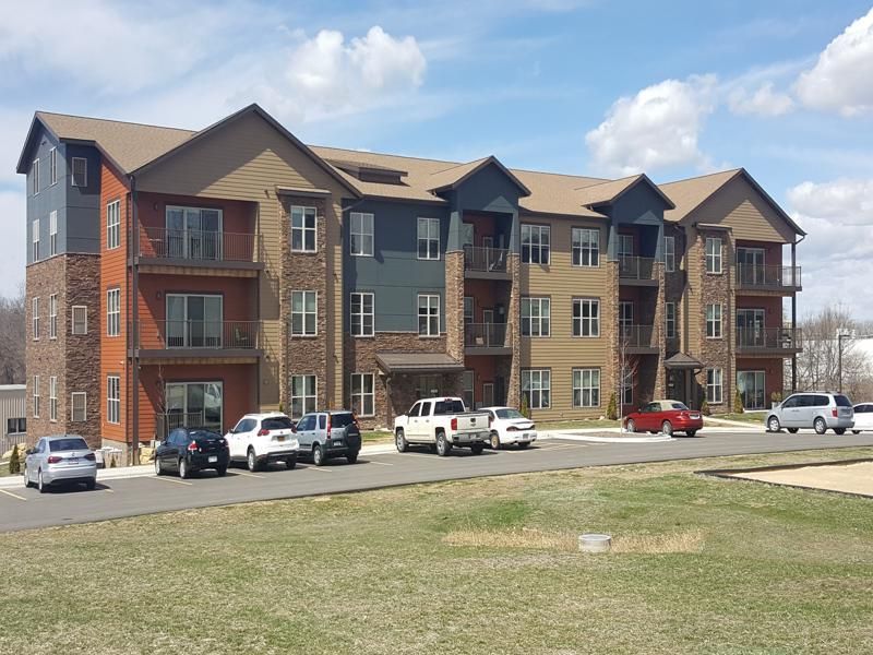 a large apartment building with cars parked in front of it