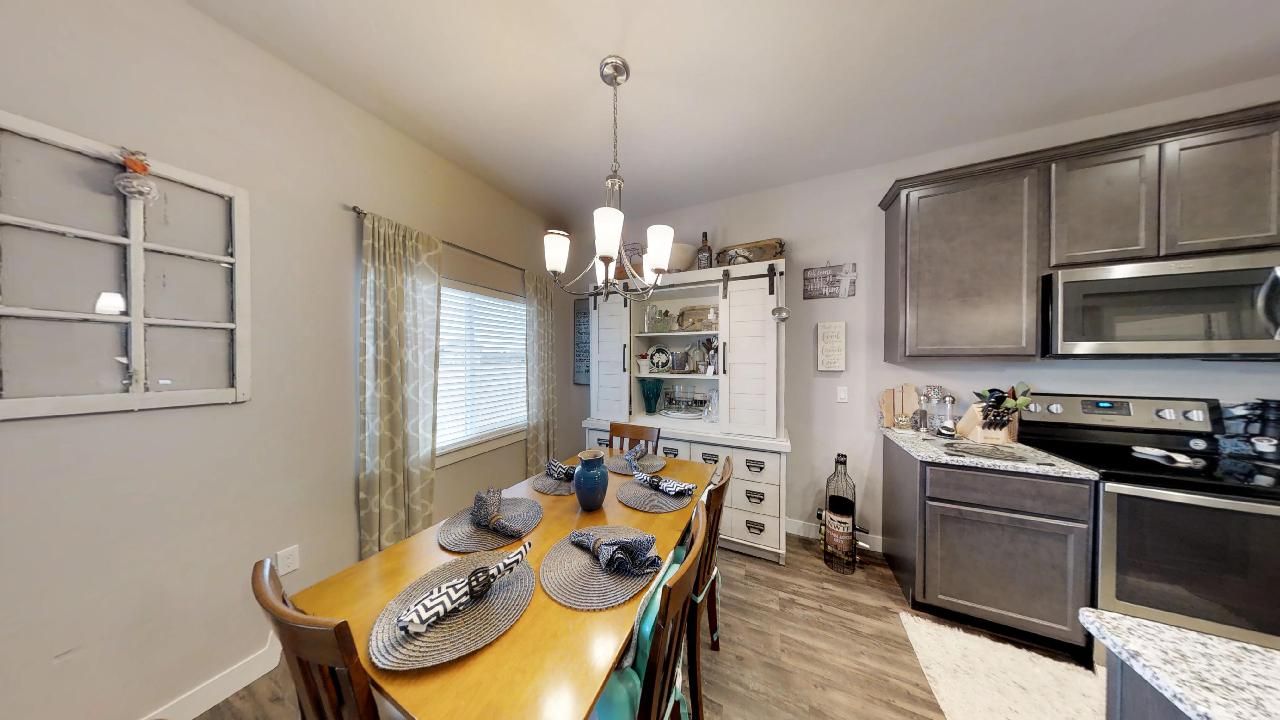 a kitchen with a table and chairs and a stainless steel stove