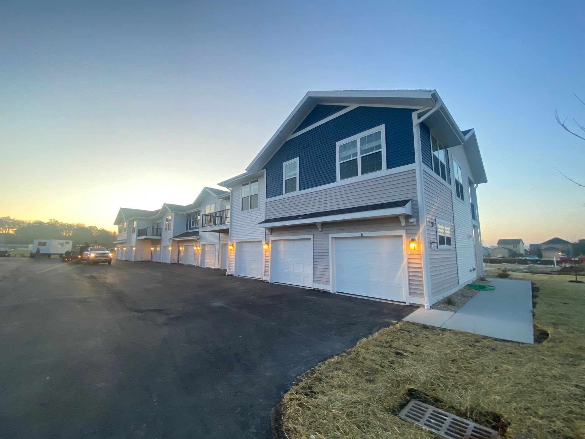 a row of houses with blue siding and white garage doors