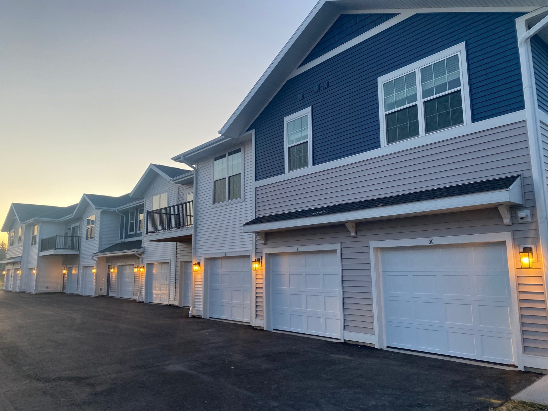 a row of houses with white garage doors with the letter k on them