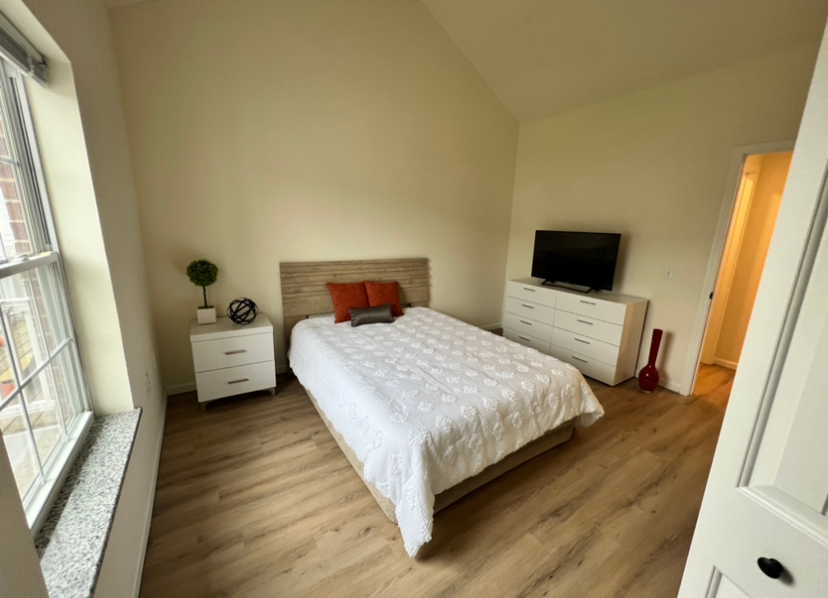 a bedroom with a bed dresser and television