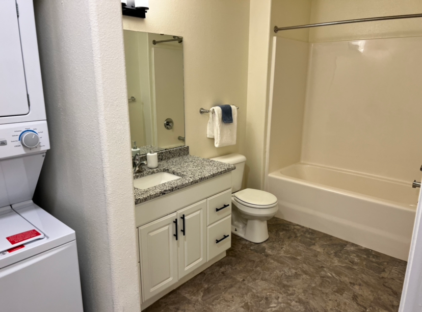 a bathroom with a washer and dryer stacked on top of each other