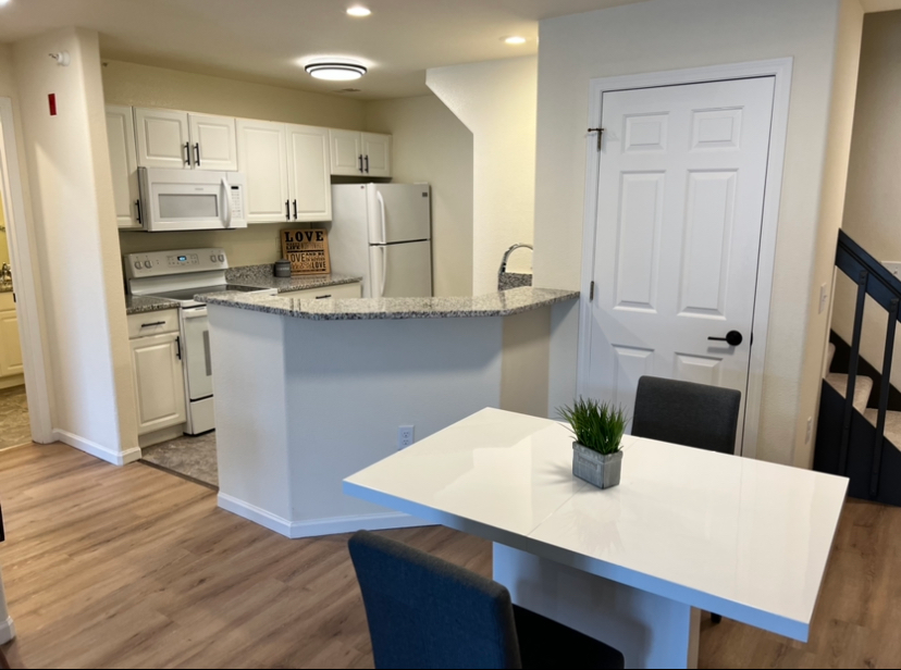a kitchen with white cabinets and a sign that says love