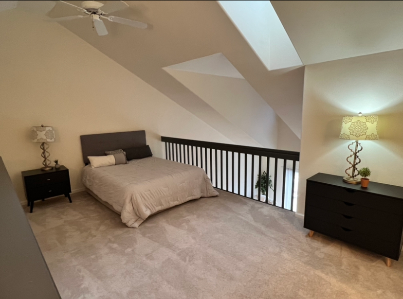 a bedroom with a ceiling fan and a bed