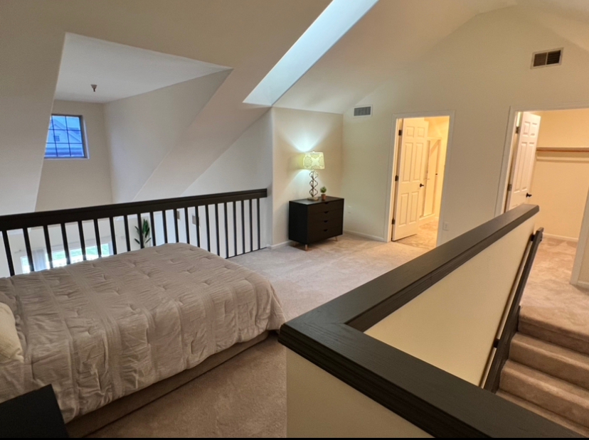 a bedroom with a bed and stairs leading up to it