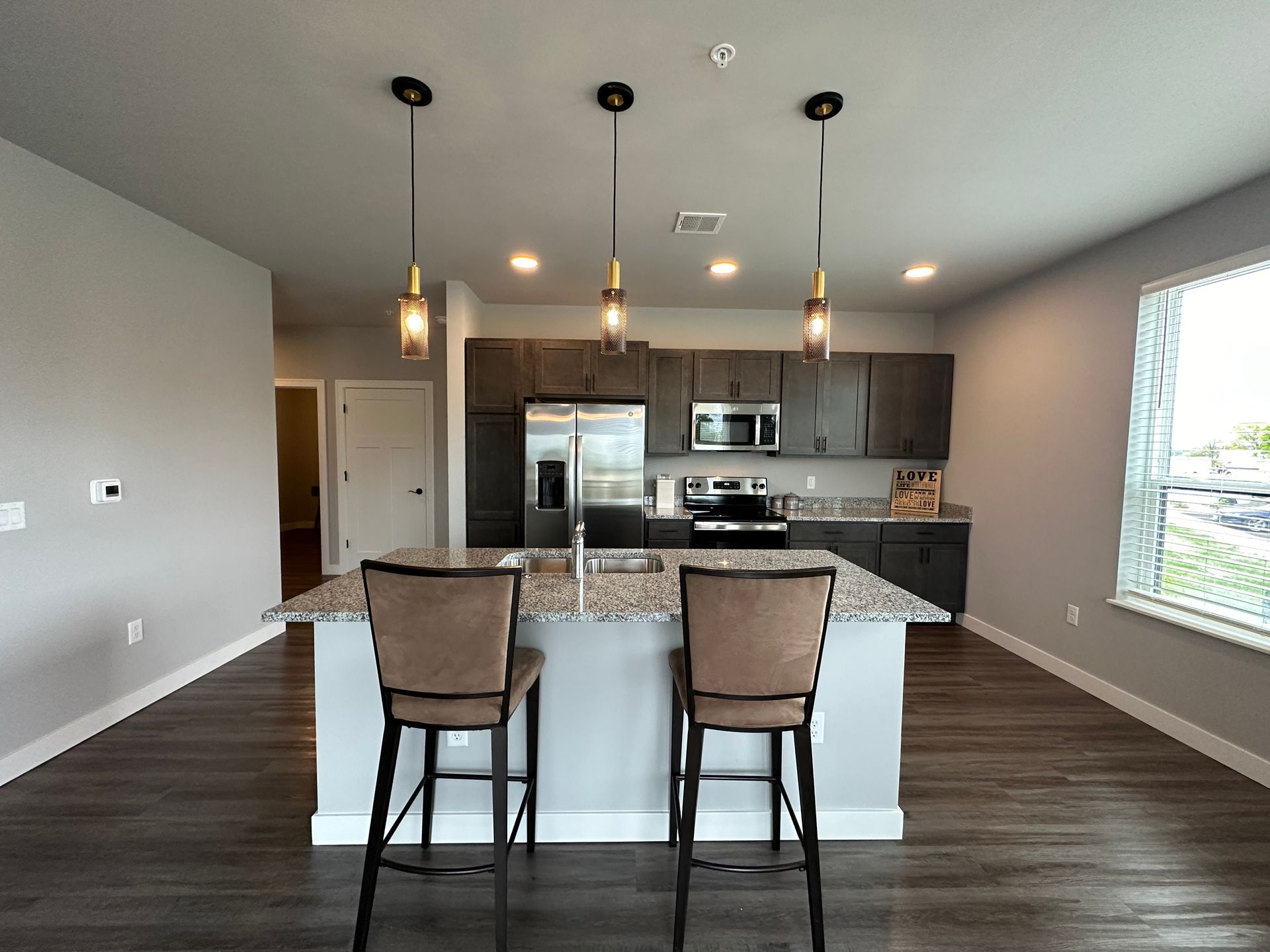 a kitchen with granite countertops and barstools 