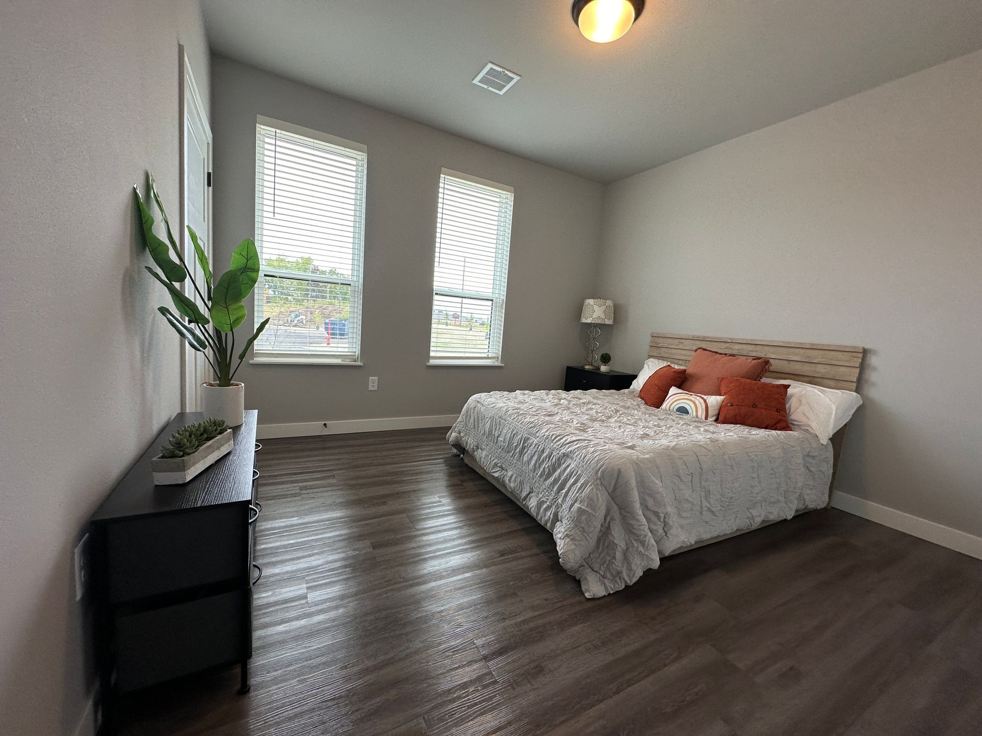 a bedroom with a large bed and two windows