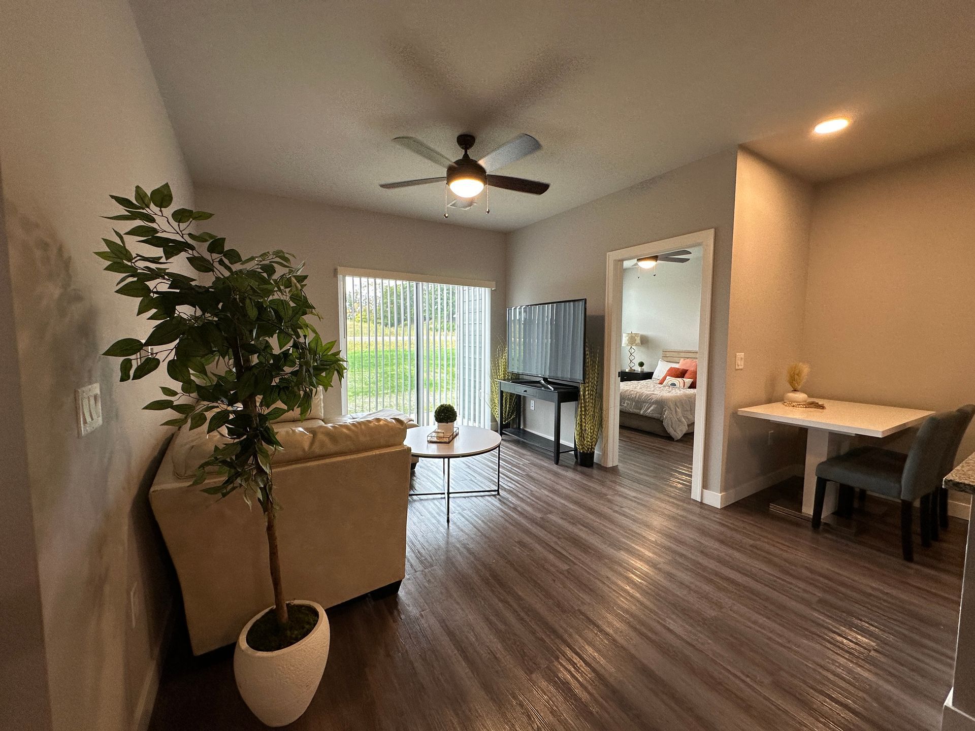 a living room with a ceiling fan and a flat screen tv