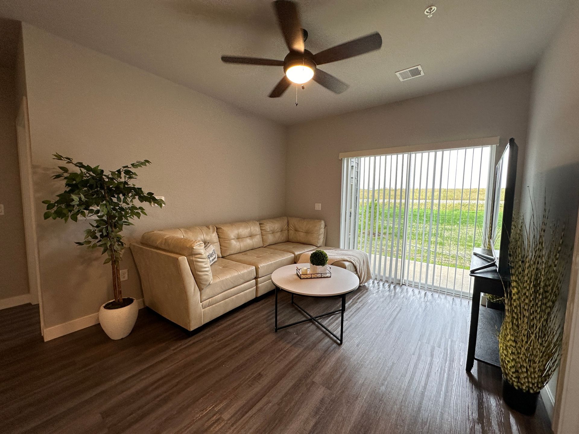 a living room with a sliding glass door and a ceiling fan