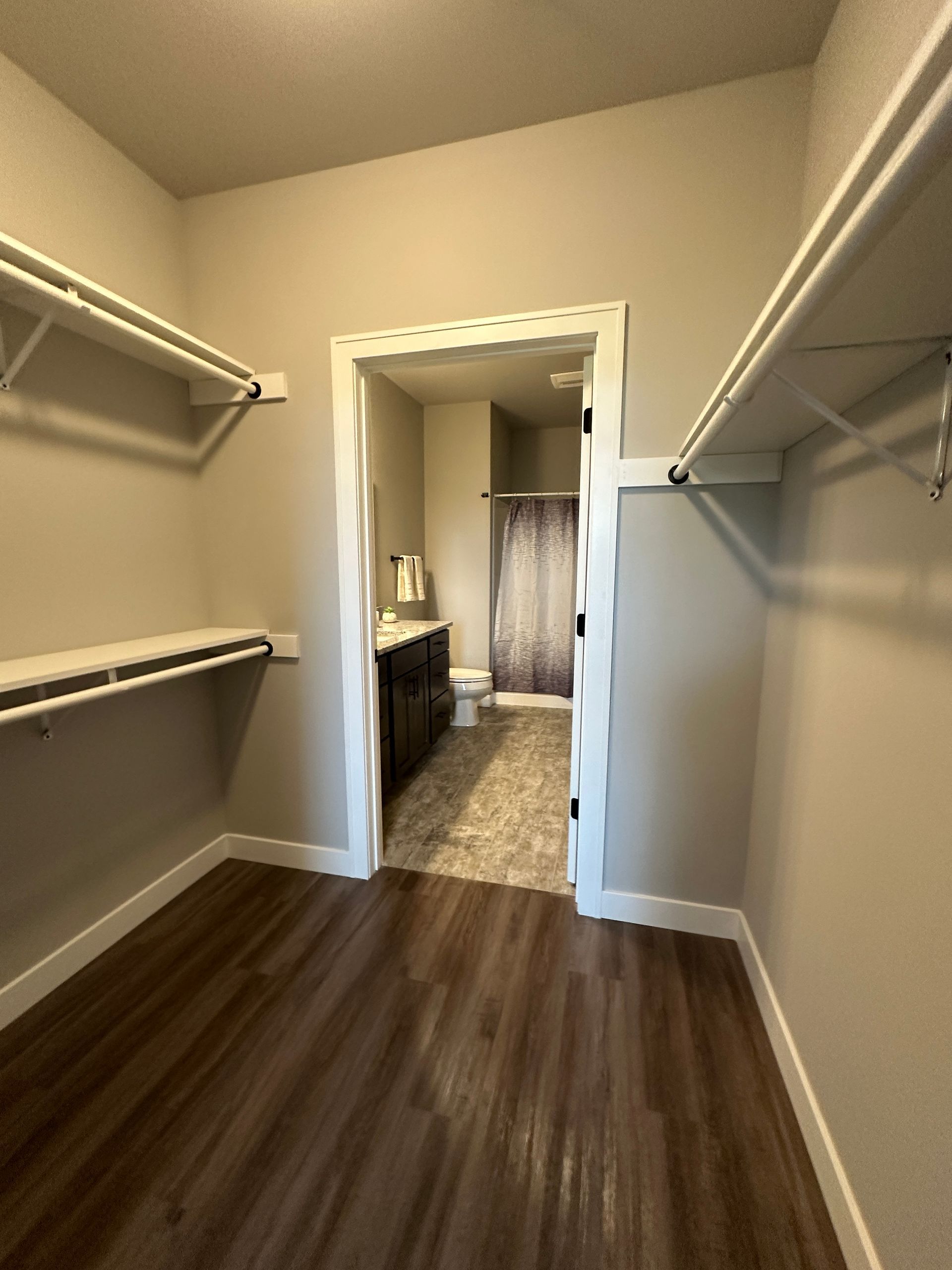 a walk in closet that leads to a bathroom