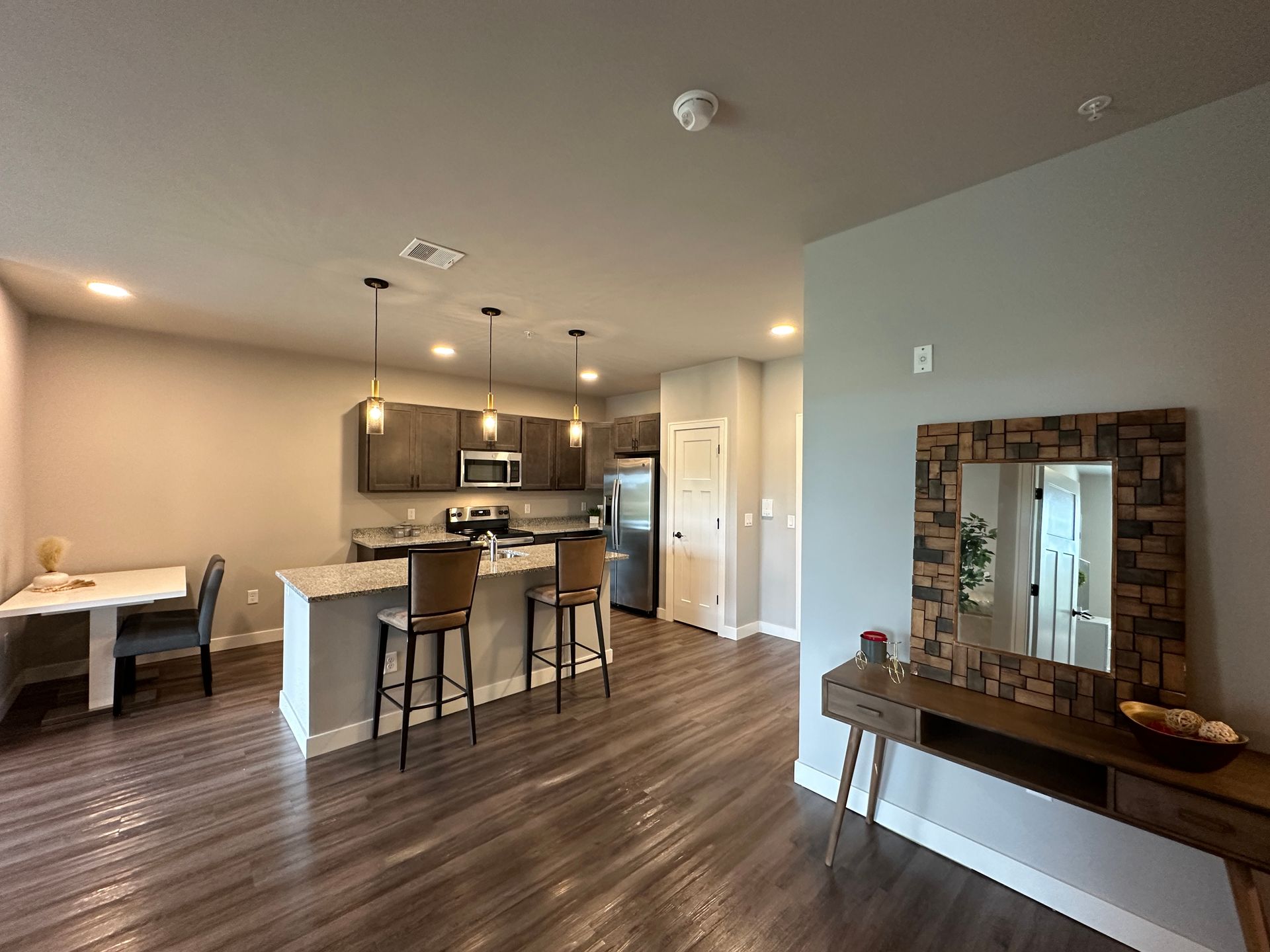a kitchen with a table and chairs and a mirror
