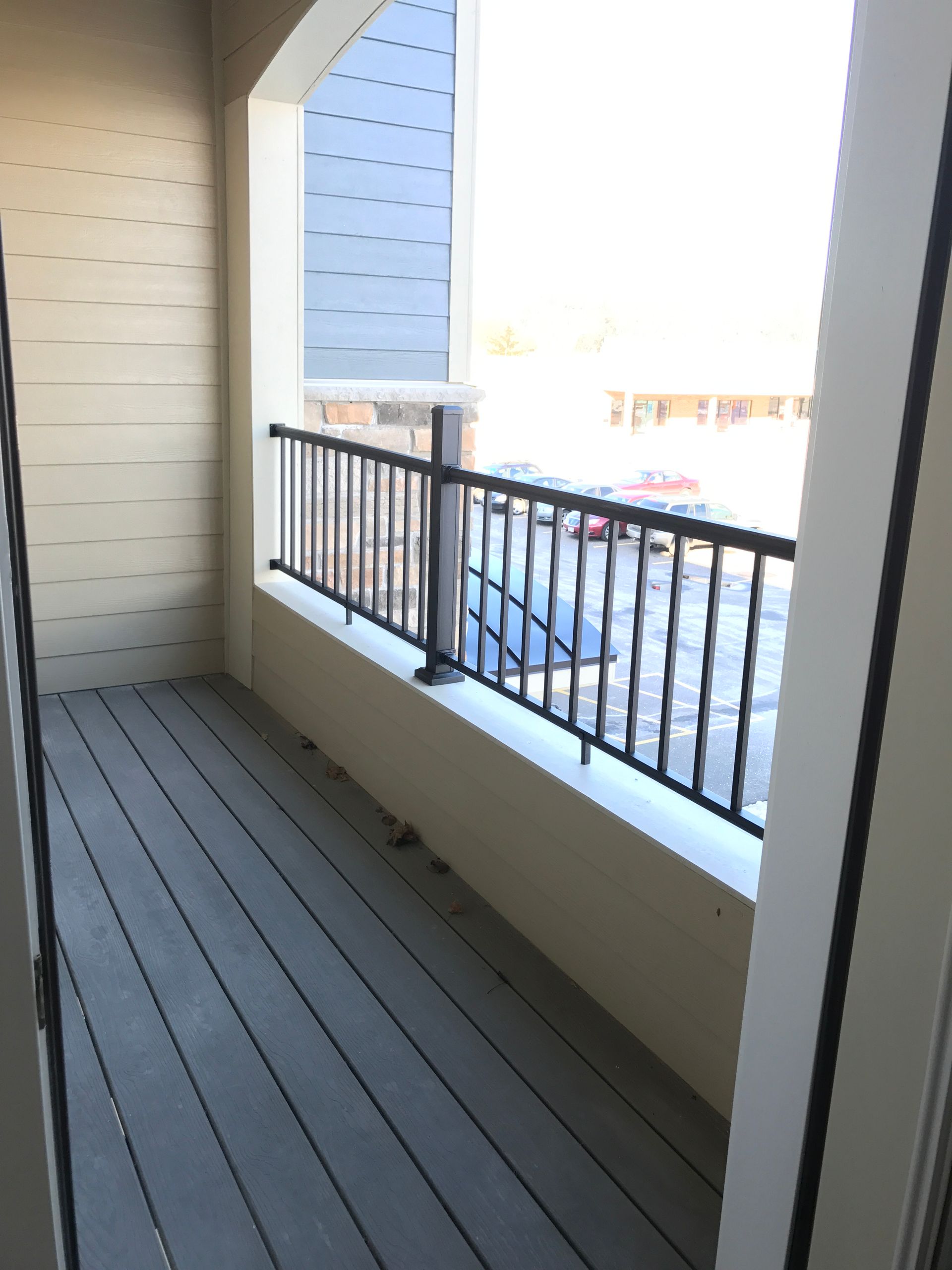 a balcony with a railing and a view of a parking lot