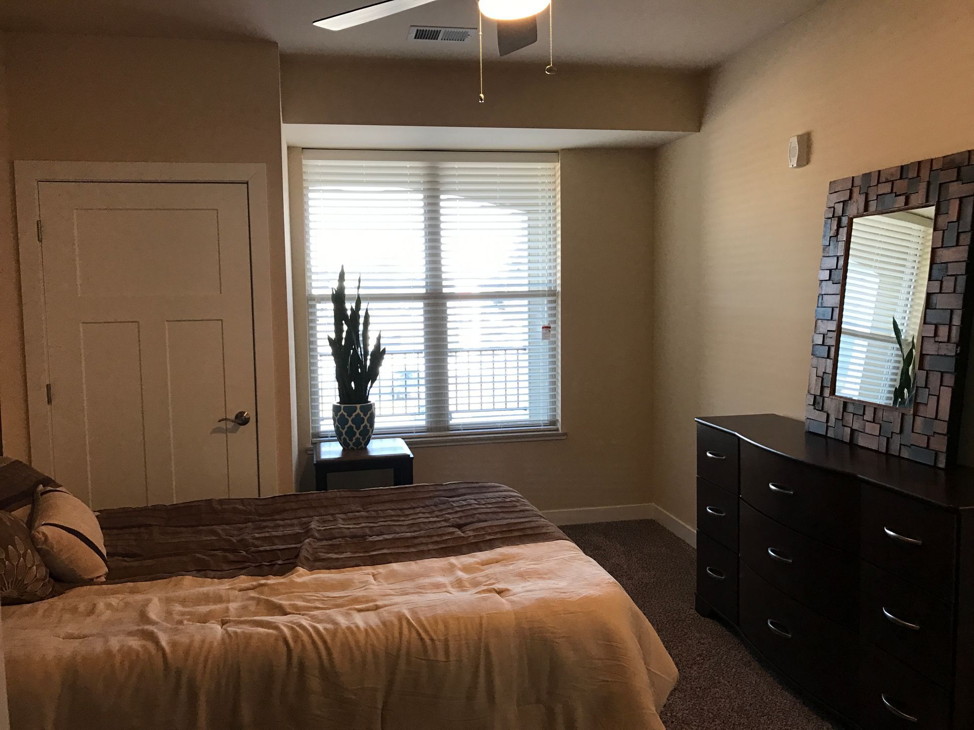 a bedroom with a bed a dresser and a mirror