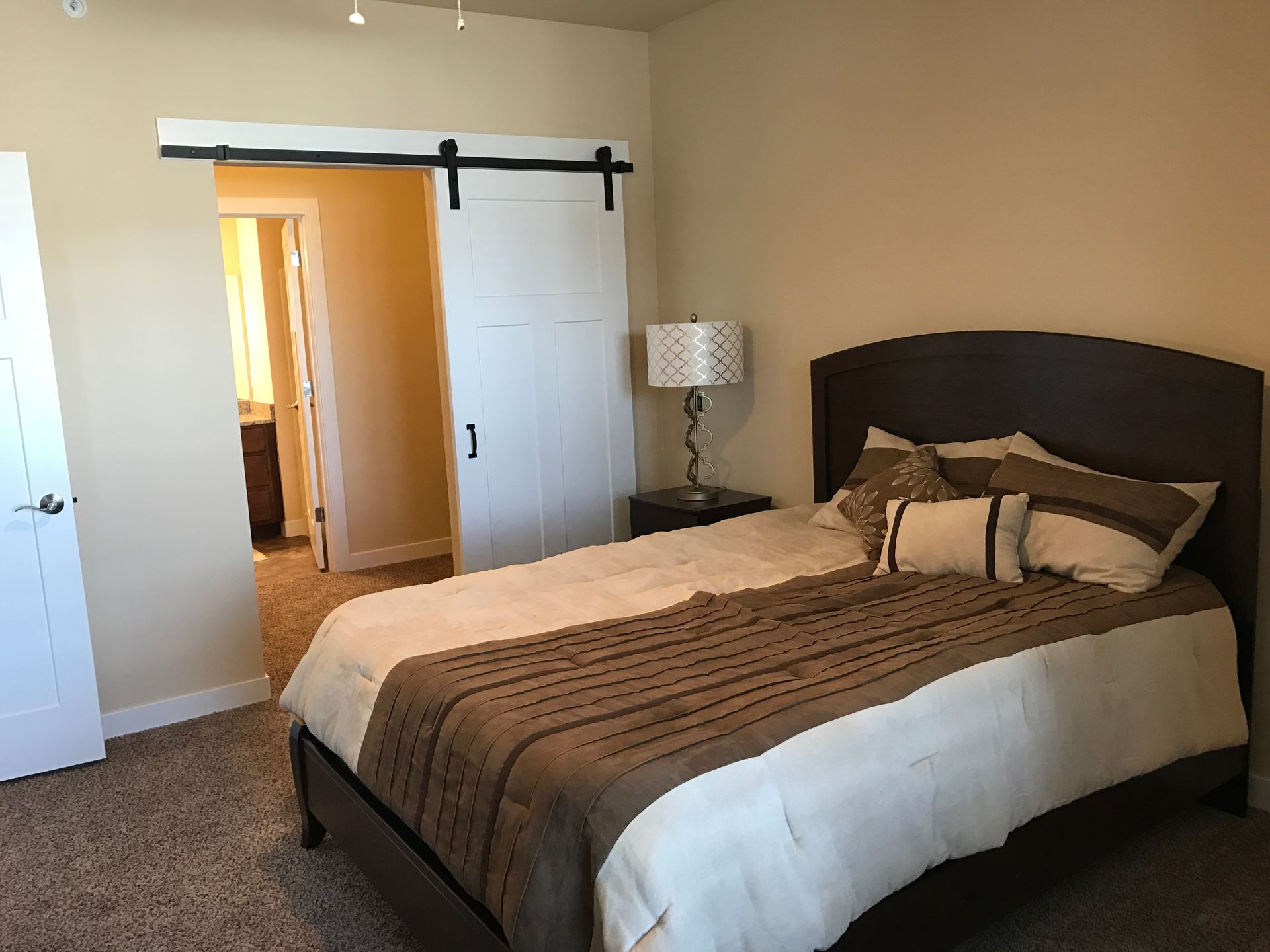 a bedroom with a bed and a sliding barn door