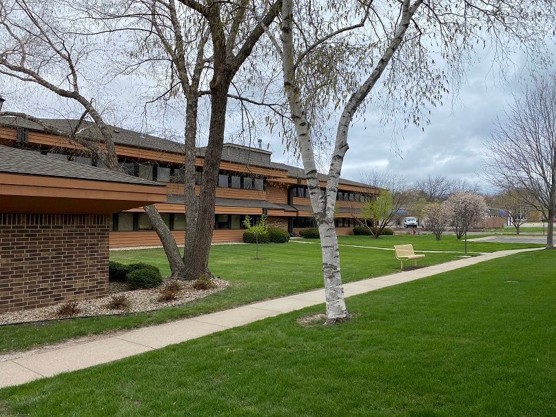 a large brick building with a lush green lawn in front of it