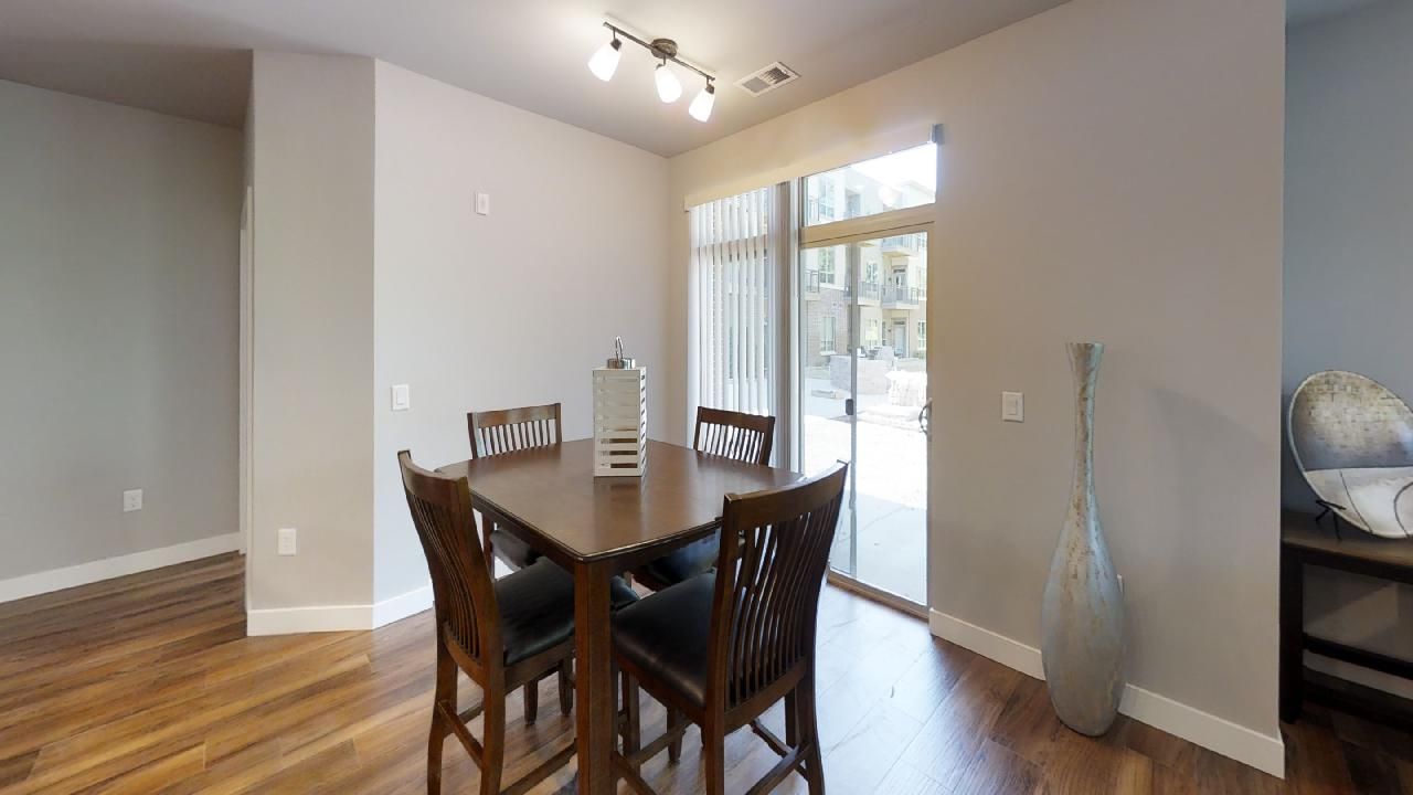 a dining room with a table and chairs and a sliding glass door
