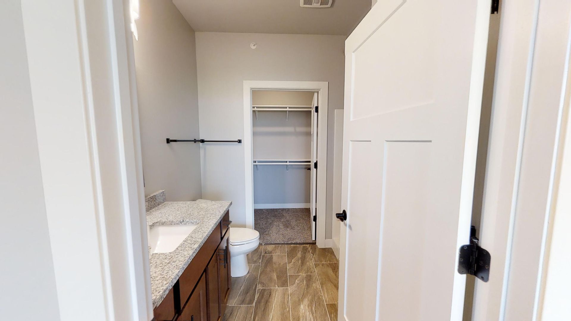 a bathroom with a toilet a sink and a walk in closet