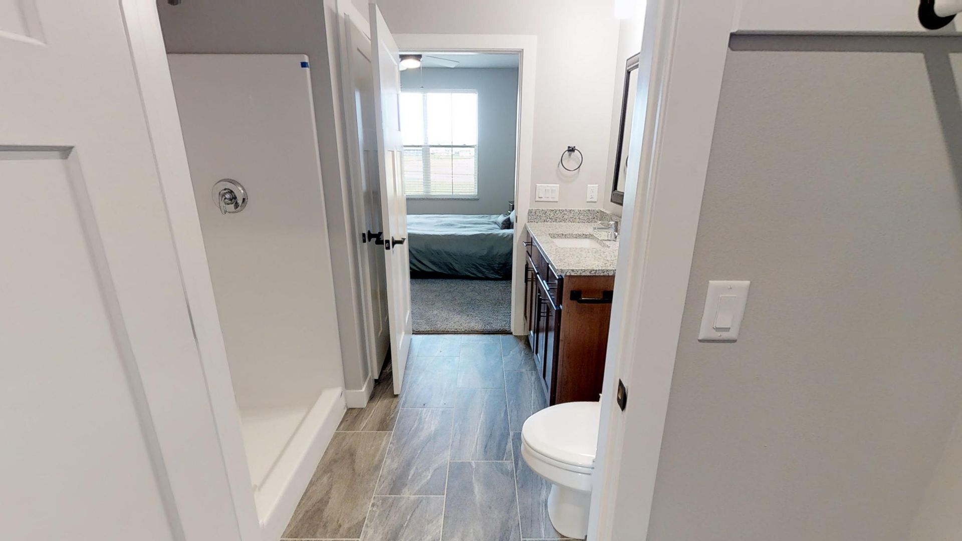 a bathroom with a toilet a sink and a walk in shower