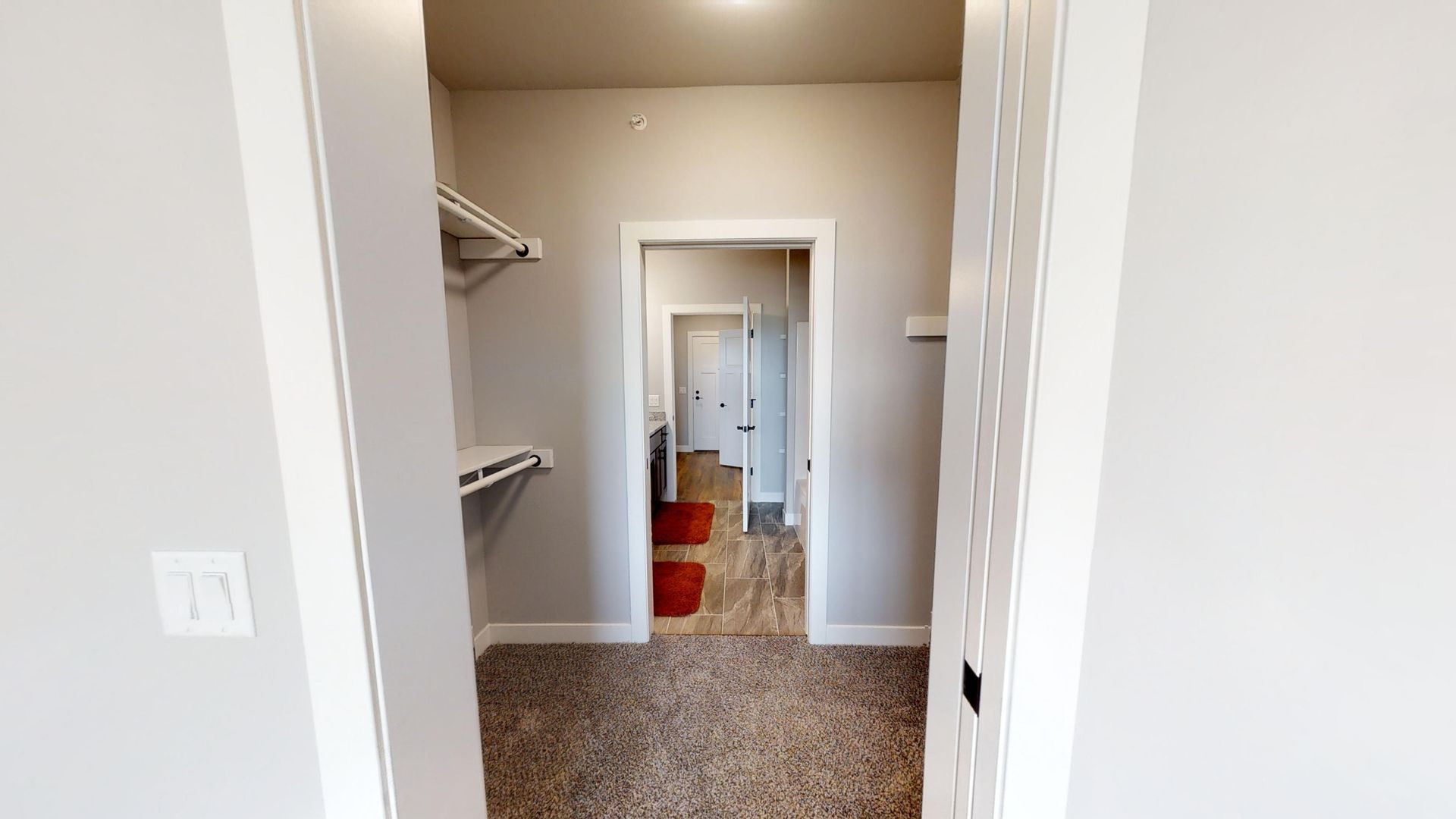 a walk in closet leading to a bathroom and bedroom