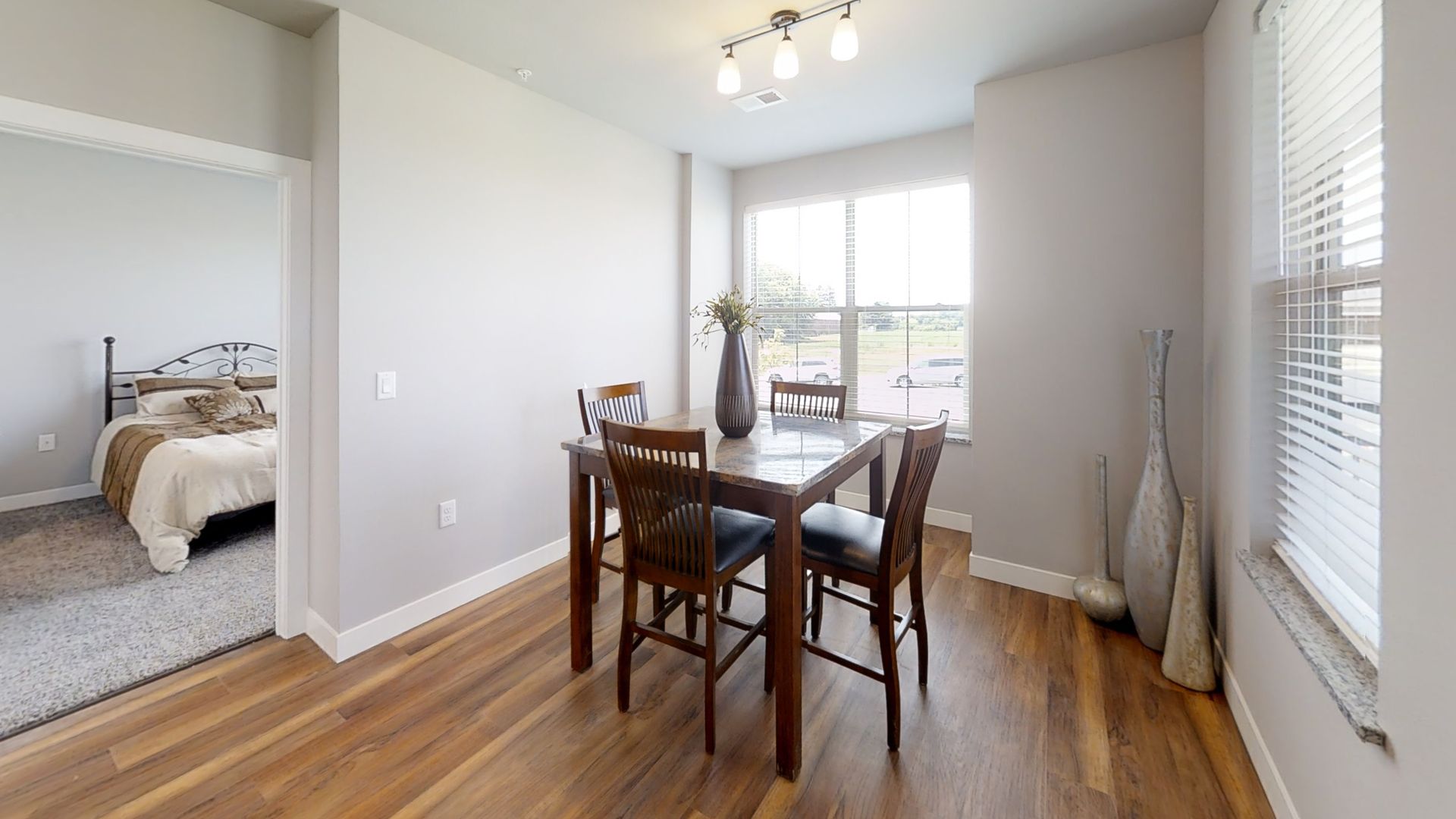 a dining room with a table and chairs next to a window