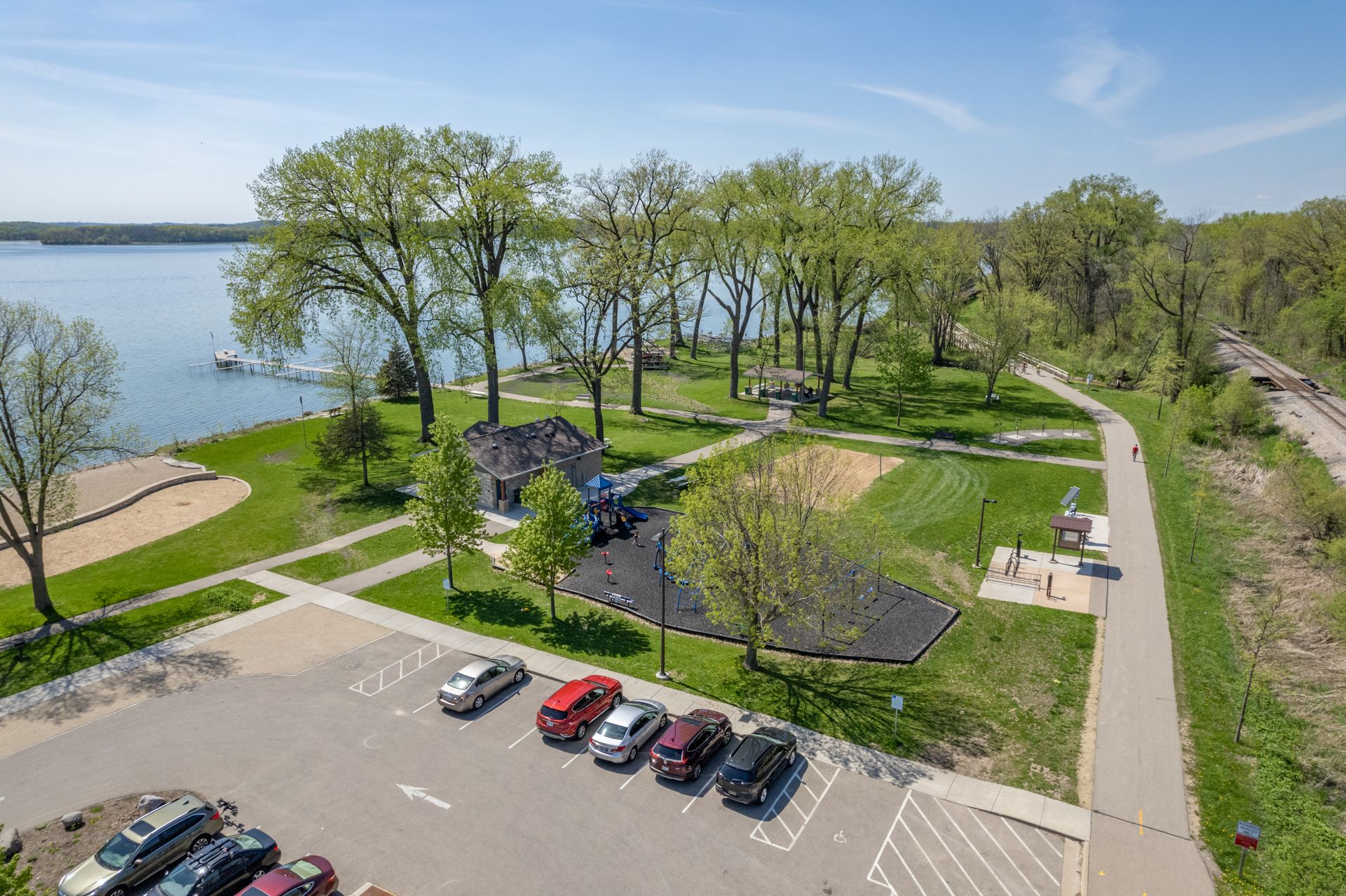 an aerial view of a park with a lake in the background