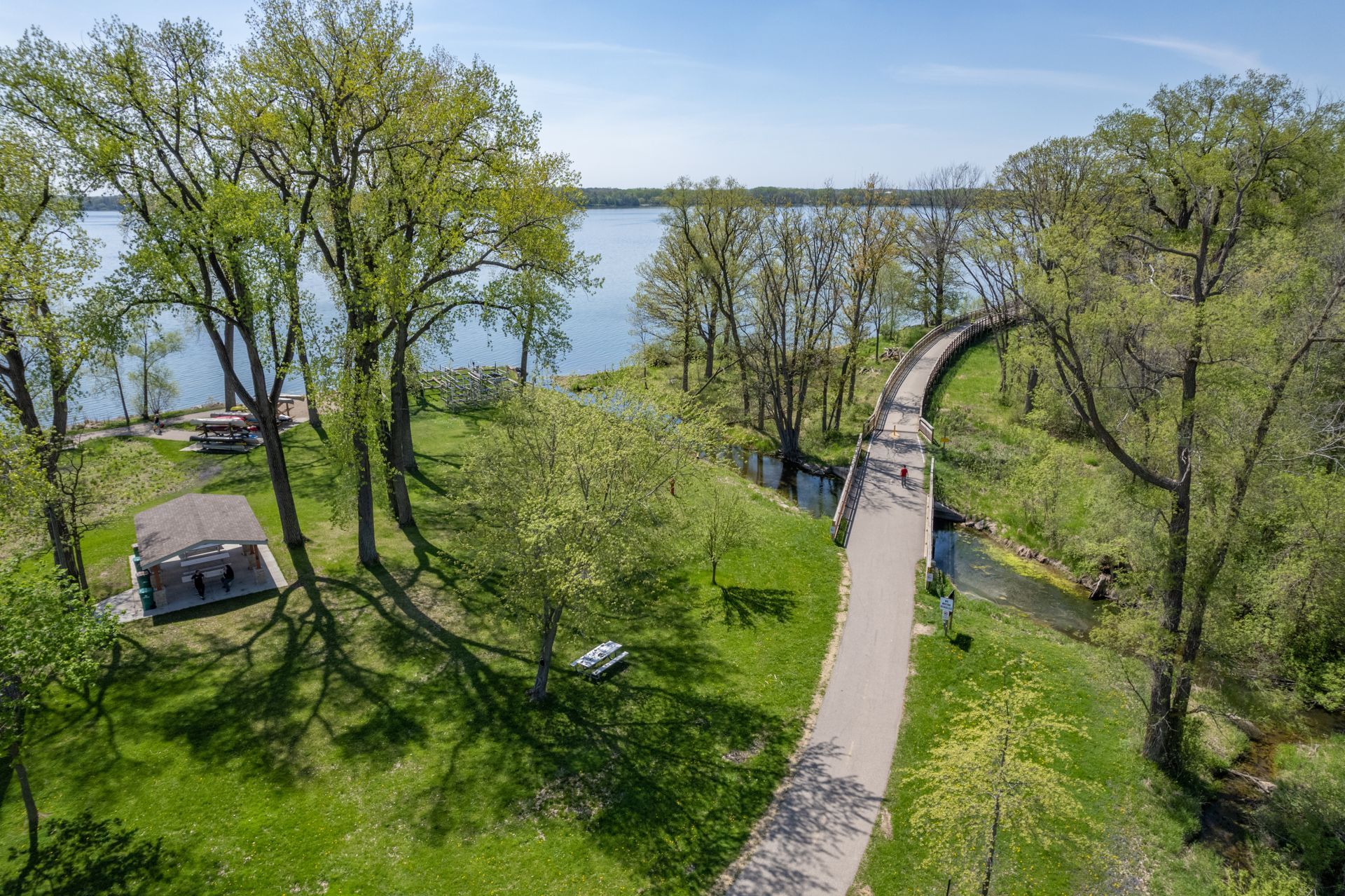 an aerial view of a park with a lake in the background