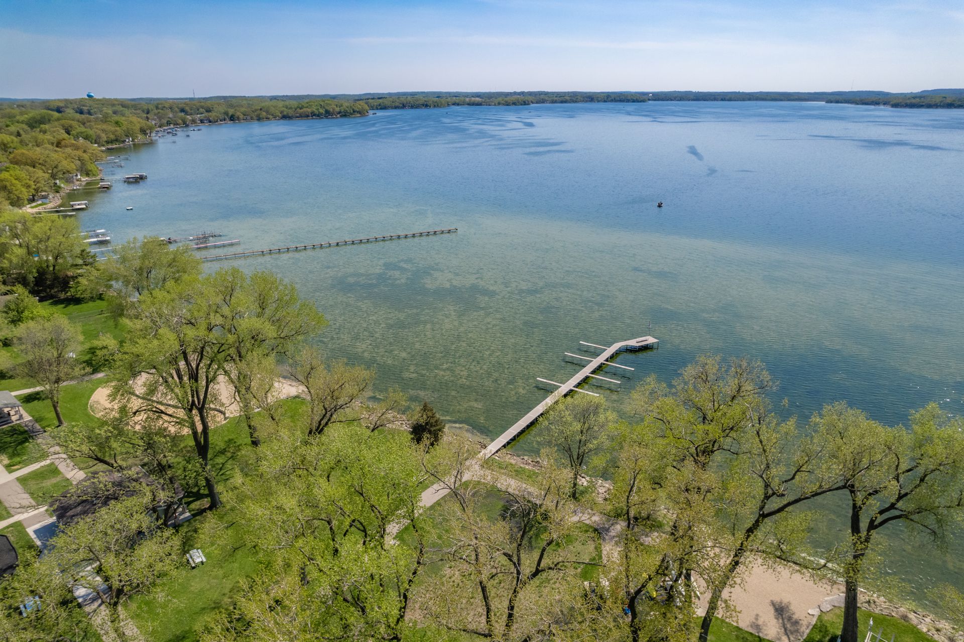 an aerial view of a lake with a dock in the middle